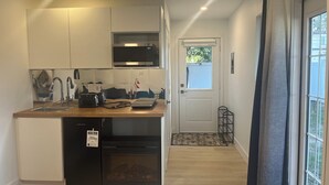 A compact kitchen with a microwave, toaster, and sink.