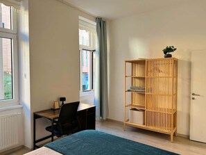 A room with a bed, a desk with a chair, a window, and a wooden bookshelf. - Servus Homes - Metro Stadthalle - Vienna Calling (Wien)