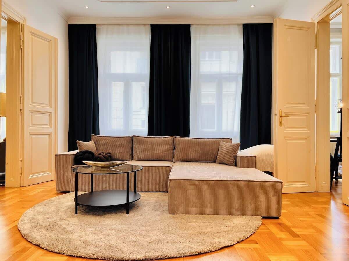 A modern living room with a sectional sofa, a round coffee table, and a fluffy rug.