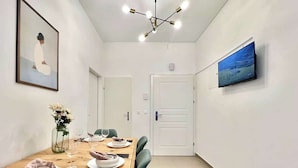 Ein Essbereich mit einem Holztisch, gedeckt für zwei Personen, einer Blumenvase und einem Bild an der Wand.