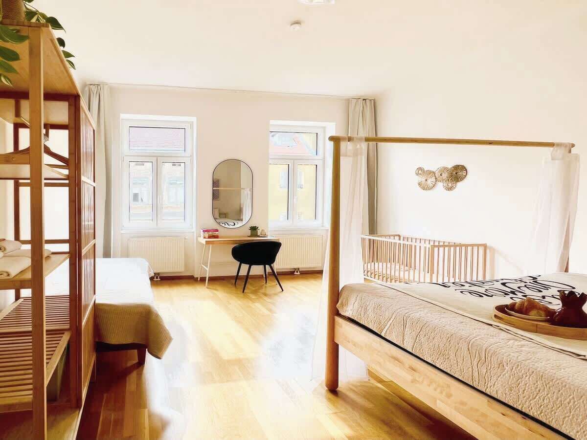 Une chambre avec un lit superposé, un bureau avec une chaise, un miroir et une fenêtre avec des rideaux.