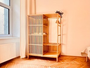 Ein Zimmer mit Holzschrank, Heizkörper und Fenster.