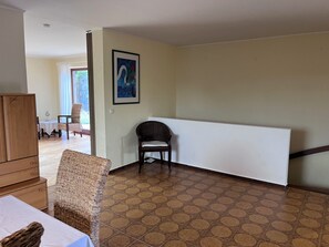 Ein Zimmer mit einem gemusterten Boden, einem gerahmten Kunstwerk an der Wand und einem Sessel.