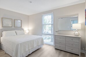 Een slaapkamer met een bed, een kaptafel, een spiegel en twee wandlampen.