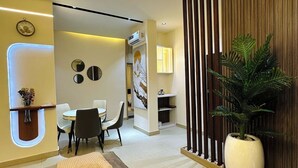 A modern interior with a sofa, dining area, and a large potted plant.