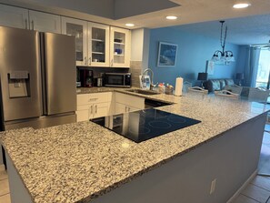 A modern kitchen with stainless steel appliances, granite countertops, and a built-in island. - Cozy 2-bedroom condo in peaceful Bradenton ground floor (Bradenton)