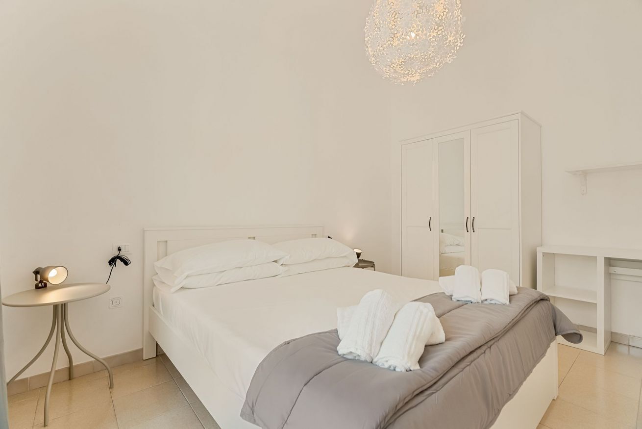 Une chambre à coucher au style minimaliste, avec un lit, une table de chevet et une armoire.
