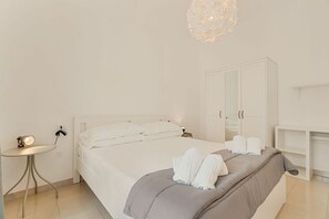 Ein schlicht eingerichtetes Schlafzimmer mit Bett, Nachttisch und Kleiderschrank.