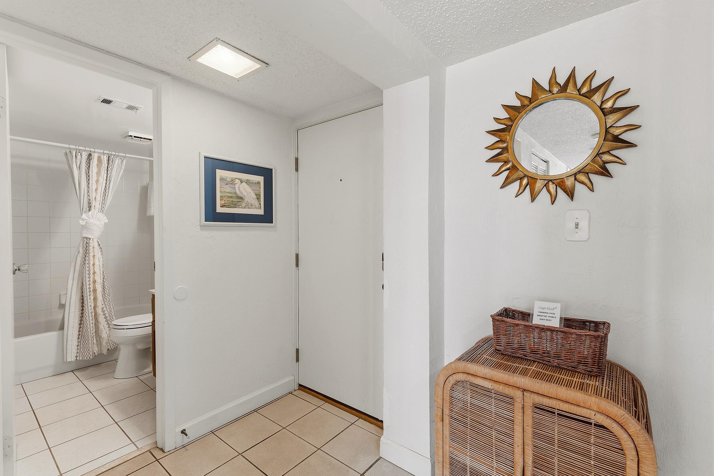 A bathroom with a shower, toilet, and a framed picture on the wall.