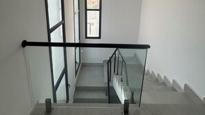 A staircase with glass railings and a view of buildings outside. - VILLA BLANCA, a vacation villa with a pool and no neighbors in sight. Garage. 4 bedrooms. (Djerba Midun)