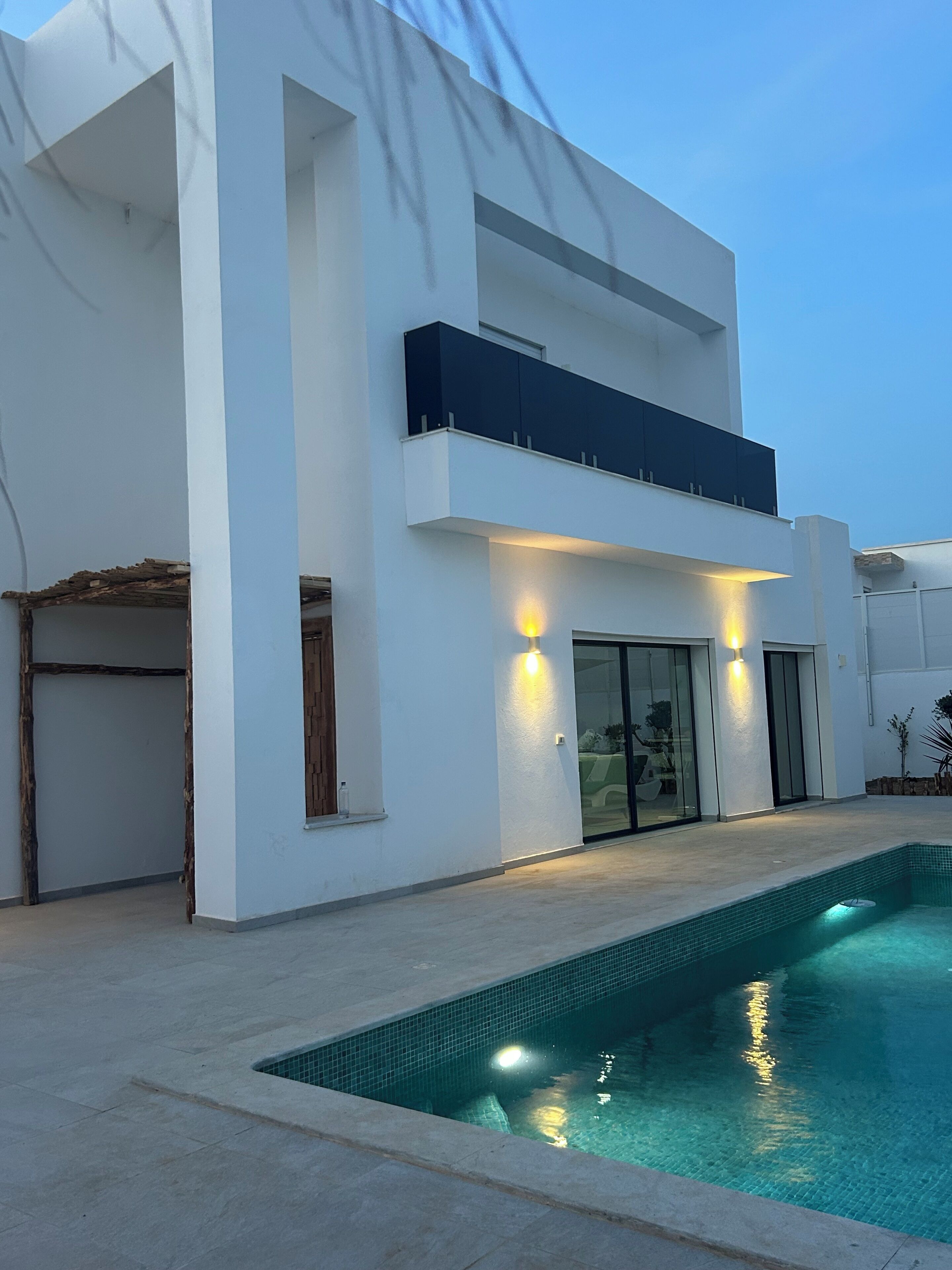 Une maison moderne à deux étages avec une piscine.