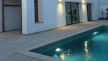 Une maison moderne à deux étages avec une piscine.