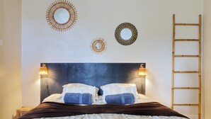 A bed with a headboard, two wall-mounted lamps, and a ladder. - Le Cocon de Boucan Canot - À 300 m de la plage (La Possession)