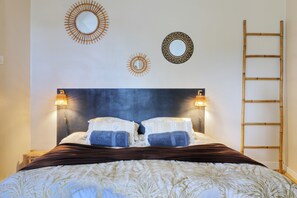 A bed with a headboard, two wall-mounted lamps, and a ladder. - Le Cocon de Boucan Canot - À 300 m de la plage (La Possession)