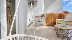 A room with a hammock, a table with a bottle, and a chair. - Le Cocon de Boucan Canot - À 300 m de la plage (La Possession)