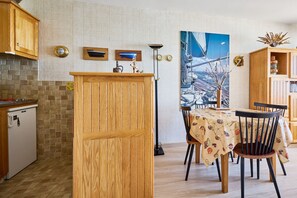 Ein Essbereich mit einem Holztisch, Stühlen und einem Bild eines Segelbootes an der Wand.