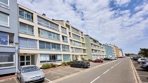 Un edificio residenziale a più piani con un parcheggio davanti.