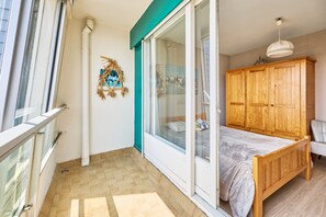 Een slaapkamer met een bed, een houten garderobe, een raam en een decoratie aan de muur.