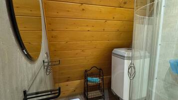 Une petite salle de bain avec un lavabo blanc, un miroir, des toilettes et un espace douche.