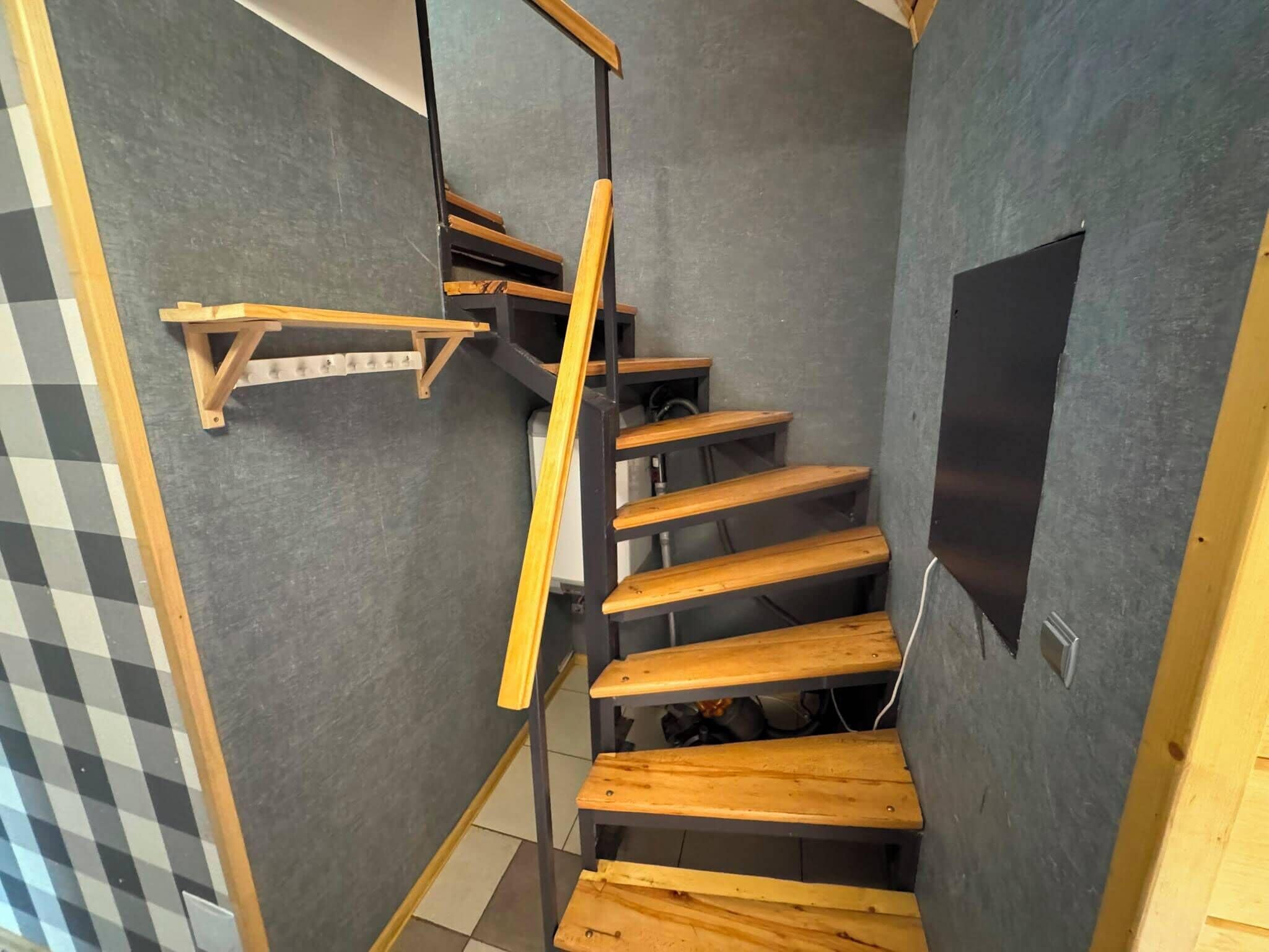 Una escalera de caracol con escalones de madera y barandilla de metal.