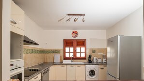 A modern kitchen with a stainless steel refrigerator, a built-in oven, a washing machine, and a coffee maker. - L'Echappée Tropicale - Maison avec piscine privée (Le Moule)