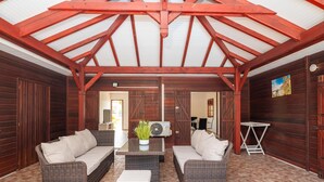 An outdoor covered patio with wicker furniture and a ceiling fan. - L'Echappée Tropicale - Maison avec piscine privée (Le Moule)