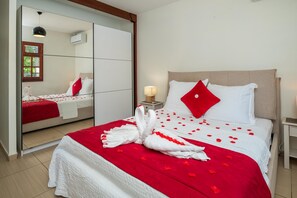 Ein Hotelzimmer mit einem Bett, einem Nachttisch mit Lampe, einem Spiegel und einem Kleiderschrank.