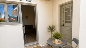 A small, enclosed outdoor area with a table and chairs, a door, and a view of a building with a dome. - The Yellow Donkey, Koumeika Traditional Gem Samos (Koumeika)