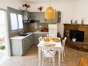 Eine Küche mit Essbereich, Kamin und einer Hängelampe.