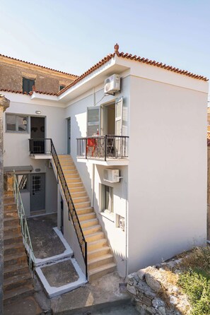 A multi-level building with a staircase, balconies, and a tiled roof. - The Yellow Donkey, Koumeika Traditional Gem Samos (Koumeika)