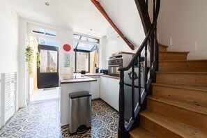 Eine Küche mit einer Holztreppe und Blick ins Freie.