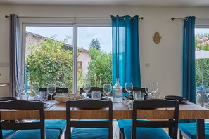 Comedor con mesa lista para cuatro sillas y vistas al exterior.