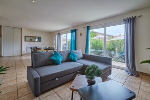 Un salón moderno con un sofá gris, una mesita y una planta en maceta.