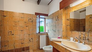 A bathroom with a toilet, sink, and window.