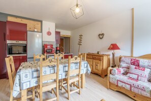 A compact living space with a dining area, kitchen, and a cozy seating area. - La Ligne des Crêtes - Station de ski à 700 m (La Bresse)