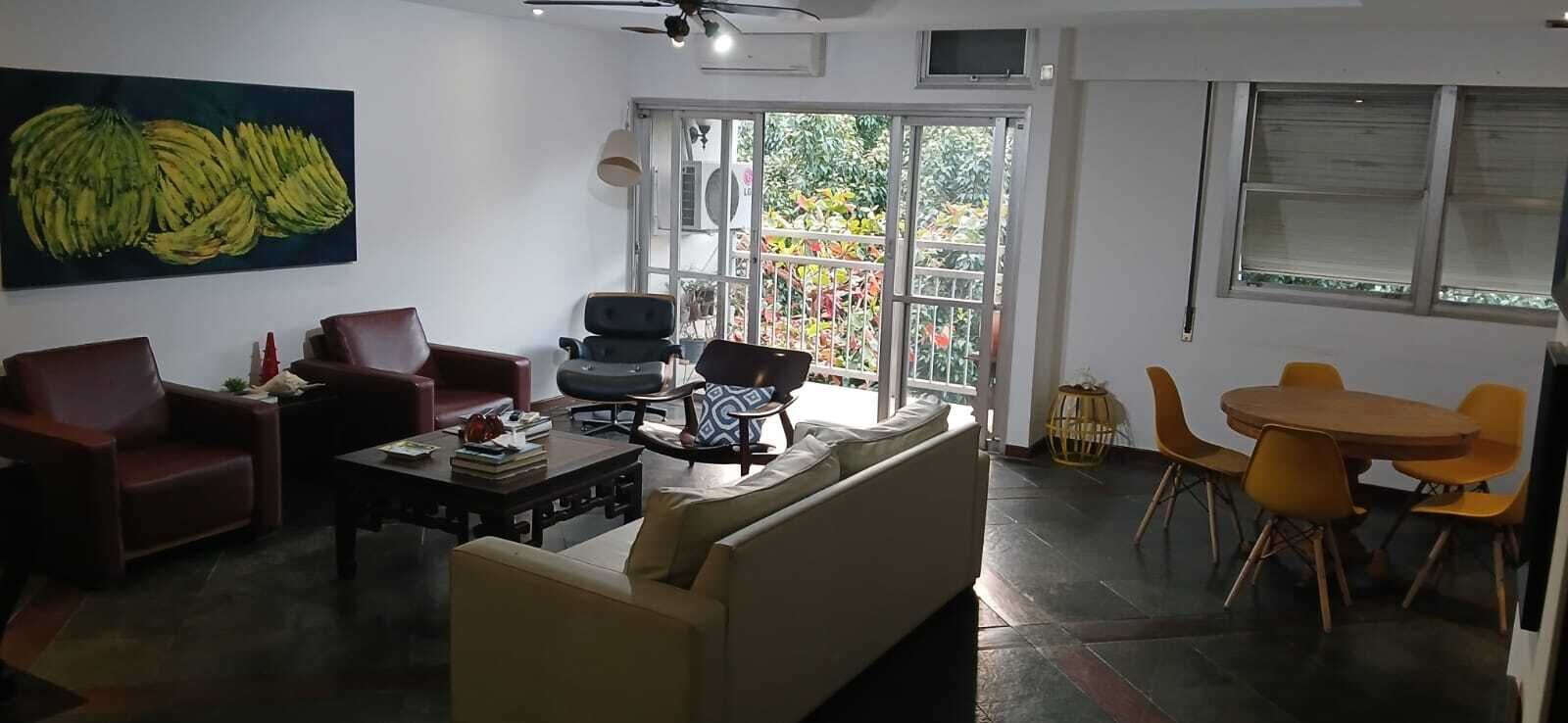 A living room with a sofa, chairs, a coffee table, and a dining area with a table and chairs.