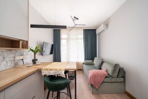 Una cocina moderna con una mesa de comedor, una silla verde y un sofá.