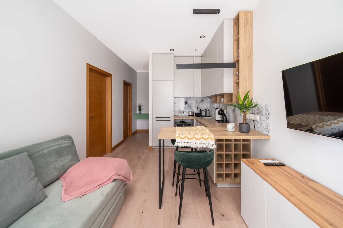 A compact living space with a kitchenette, a dining area, and a seating area with a sofa and chairs.