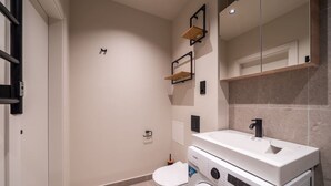 Un baño moderno con inodoro, lavadora y lavamanos.