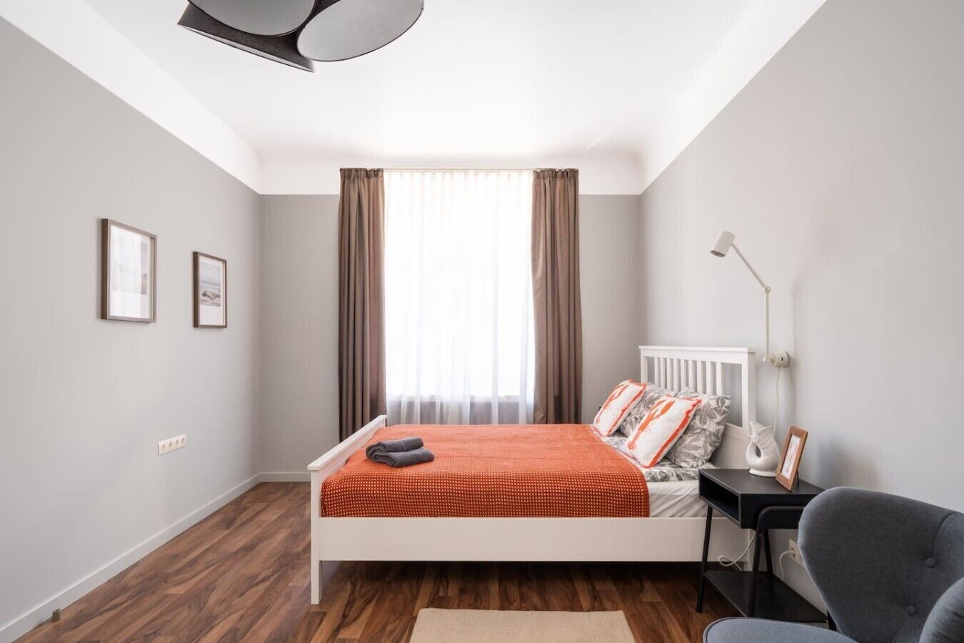 Een moderne slaapkamer met een bed, een bureau en een stoel.
