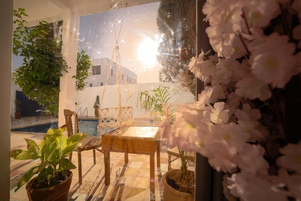 Una habitación con vista a un edificio, una piscina y plantas en macetas.