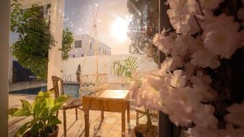 Una habitación con vista a un edificio, una piscina y plantas en macetas.