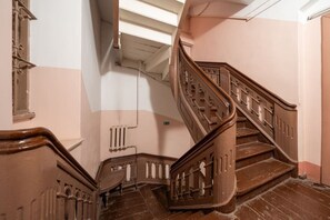 Una scala a chiocciola con ringhiere in legno decorate e un termosifone sulla parete.