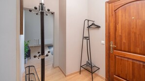 Ein Flur mit Kleiderhaken, Schuhablage und Holztür.