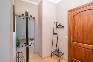 A hallway with a coat rack, a shoe rack, and a wooden door. - Heart of Old Town TOP location 1-Bedroom Apartment (Riga)