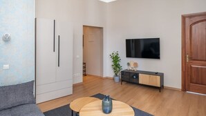 Ein modernes Wohnzimmer mit einer Couch, einem Couchtisch, einem Fernseher und einem Holzschrank.