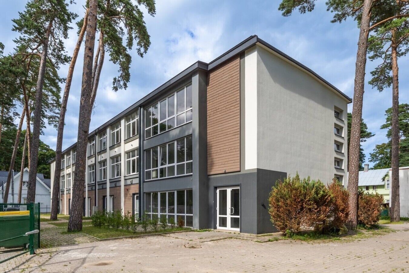 A modern multi-story building with large windows and a mix of brick and concrete exterior.