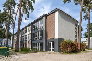 A modern multi-story building with large windows and a mix of brick and concrete exterior.