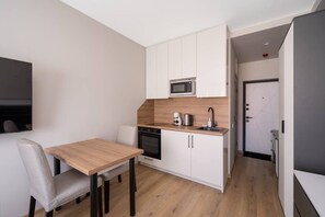 A compact kitchenette with a microwave, coffee maker, and sink.