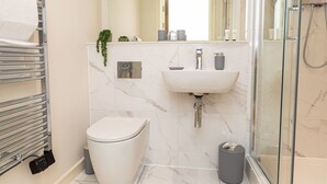 A modern bathroom with a toilet, sink, and shower. - Birmingham City Retreat No 117 (Birmingham)